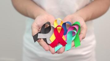 värld cancer dag, februari 4. färgrik band för stödjande människor levande och sjukdom. sjukvård, stridande, medicinsk och nationell cancer överlevnad dag, autism medvetenhet dag begrepp video