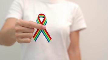 hand holding LGBTQ Rainbow ribbon for Support Lesbian, Gay, Bisexual, Transgender and Queer community and Pride month concept video