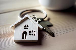 Real estate concept - Key ring and keys on white wooden background photo