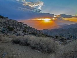 Image of a spectacular weather scene with impressive sun rays through a hole in the clouds photo