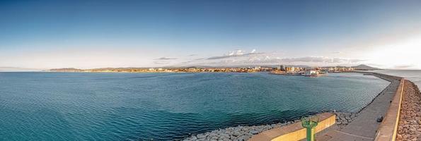 Drone panorama of the Spanish town of Vinaros with the large breakwater at the entrance to the port during sunrise photo