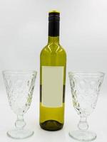 botella de vino y copas con etiqueta vacía para diseño propio foto