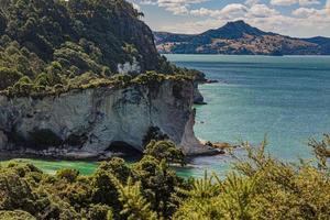 View over cliffy shore of Te Whanganui-A-Hei Marine Reserve on Northern island in New Zealand in summer photo