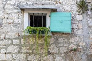 Closeup of an old natural stone wall with a window typical texture photo