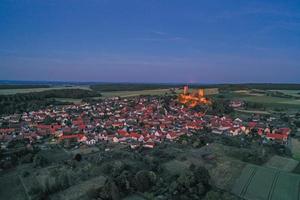 Drone image of Muenzenberg with illuminated castle ruins in Germany photo