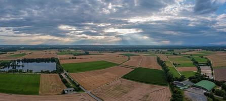 Drone panorama over Hessian fen with dramatic cloud formations and sun beams