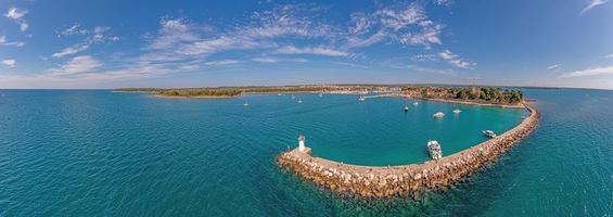 Drone panorama over the Croatian coastal town Novigrad with harbor and promenade taken from the sea side during the day photo