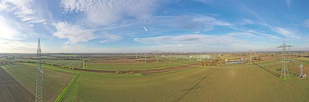 Aerial panoramic picture of a transformer station with many insulators and cables during the day photo