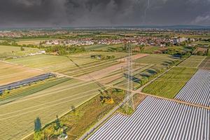 Panoramic image of high voltage road with high power pylons in evening light and approaching thunderstorm photo