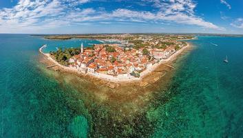 Drone panorama over the Croatian coastal town Novigrad with harbor and promenade taken from the sea side during the day photo