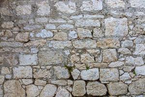 Closeup of an old natural stone wall with typical texture photo