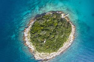 Vertical top view on a small island in the mediterrean sea close to the shore photo