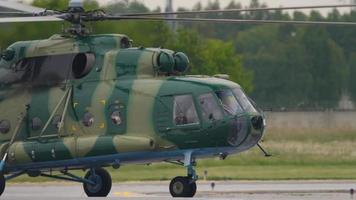 novosibirsk, rússia, 17 de junho de 2020 - helicóptero militar mi 8 taxiando ao longo da pista. um caminhão de bombeiros está dirigindo ao fundo. aeroporto internacional de tolmachevo, novosibirsk