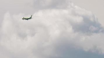 NOVOSIBIRSK, RUSSIAN FEDERATION JUNE 27, 2021 - Airplane of S7 airlines flight in the sky in cloudy cloudy summer weather. The plane lands against a background of white and gray clouds. Travel video