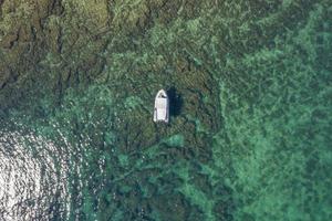 vista superior sobre el anclaje de botes pequeños en aguas turquesas planas cerca de la orilla de rovinj foto