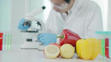el científico comprueba los residuos de alimentos químicos en el laboratorio. expertos en control inspeccionan la calidad de frutas, verduras. laboratorio, peligros, rohs, encontrar sustancias prohibidas, contaminar, microscopio, microbiólogo video
