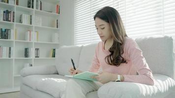 ispirazione, scrittore, scrittura ,creativo ,ricreazione per immaginare, bellissimo Asia attraente giovane donna scrittura idee su taccuino, per fare elenco, bene pensiero opera, giornalista, elegante, sognare Immagine, rilassare video