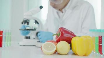 el científico comprueba los residuos de alimentos químicos en el laboratorio. expertos en control inspeccionan la calidad de frutas, verduras. laboratorio, peligros, rohs, encontrar sustancias prohibidas, contaminar, microscopio, microbiólogo video