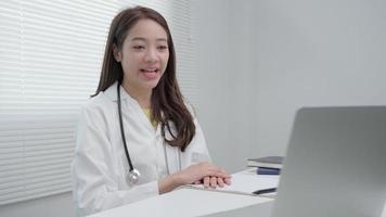 telemedicinsk. läkare förklarar de medicin till de patient förbi video konferens. asiatisk läkare är behandla patienter genom telekommunikation medan beskrivande de sjukdom . teknologi för hälsa.