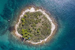 Vertical top view on a small island in the mediterrean sea close to the shore photo
