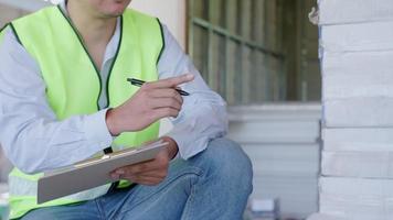 l'inspecteur ou l'ingénieur inspecte la maison de construction à l'aide d'une liste de contrôle. ingénieurs et architectes ou entrepreneur comptent les matériaux pour la construction. bâtiment, chèque, assurance maison, qualité, contremaître. video