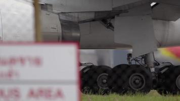 Airplane taxiing down the runway, landing gear and engine close up video