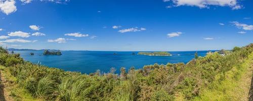 Panoramic view over cliffy shore of Te Whanganui-A-Hei Marine Reserve on Northern island in New Zealand in summer photo