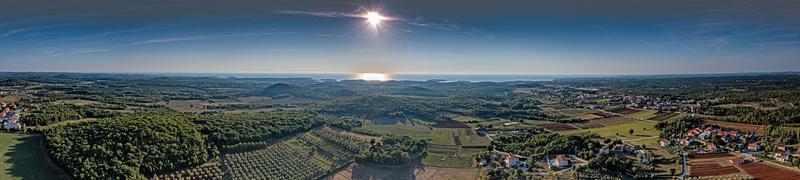 Drone panorama over the Istrian Adriatic coast near Porec taken from high altitude with clear sky and impressive reflections of the sun in the sea photo