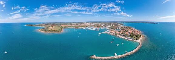 Drone panorama over the Croatian coastal town Novigrad with harbor and promenade taken from the sea side during the day photo