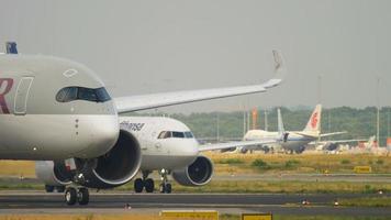 frankfurt am main, alemania 19 de julio de 2017 - qatar airways airbus 350 a7 todo gira para comenzar antes de la salida en la pista 18 y lufthansa airbus 320neo d aina rodando. fraport, frankfurt, alemania video