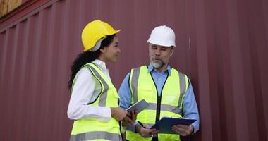 Handheld panning shot, middle-aged Caucasian business engineer man and pretty secretary female checking transport container, They are talking and write into report paper on clipboard at storage port video