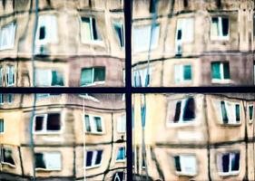 crooked reflection of houses in a glass window photo