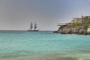 Sailing ship in the turquoise waters of the caribbean island of St. maarten during daytime in summer photo