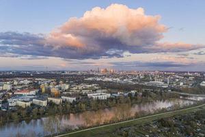 Aerial panoramic picture of river Main and the Frankfurt skyline during sunset in afterglow with illuminated cloud photo
