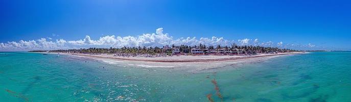 Panorama over a tropical beach taken from the water during the day photo