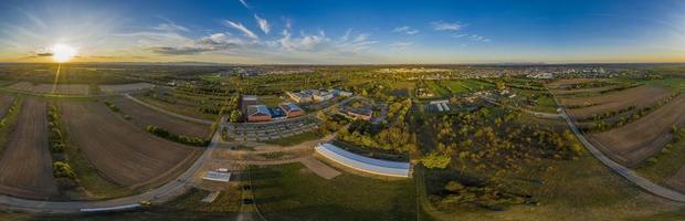 360 Panoramic drone picture of the city Moerfelden-Walldorf with the skyline of Frankfurt in the background at evening photo