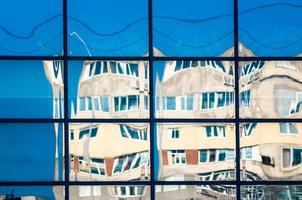 crooked reflection of houses in a glass window photo