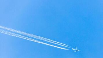 Four engined airplane during flight in high altitude with condensation trails photo