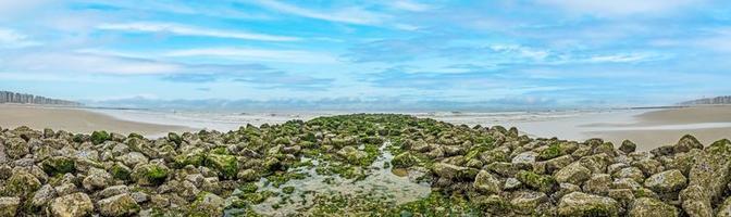 imagen panorámica a lo largo de un rompeolas en la playa del mar del norte middlekerke foto