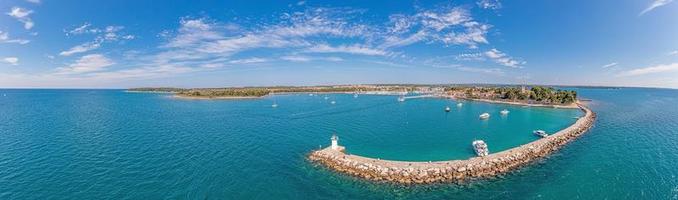 Drone panorama over the Croatian coastal town Novigrad with harbor and promenade taken from the sea side during the day photo