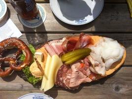 imagen de arriba hacia abajo de un típico brotzeit bávaro con diferentes carnes y bretzel foto