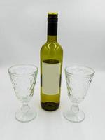 botella de vino y copas con etiqueta vacía para diseño propio foto