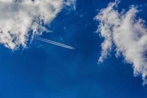 Four engined airplane during flight in high altitude with condensation trails photo