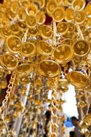 Look up view of of many small golden bells was hung in a group in Thai temple. photo