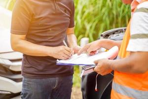 Closeup and crop traffic accident and insurance agent working on report form with car accident claim process. photo