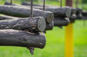 old wooden logs on a rope on a green background close up photo