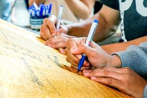 lumpoon, tailandia 2017: la mano de primer plano del nombre de escritura humana en el manto de la pagoda es una tradición de los norteños tailandeses que creen hacer lo que se considera haber adorado al buda. foto