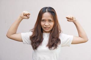 las mujeres asiáticas flexionan sus músculos y muestran su fuerza. foto