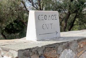 stone with the inscription exit in Greek and English photo