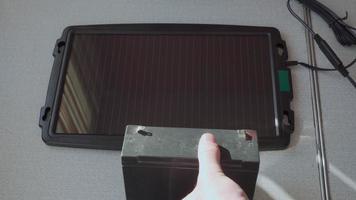 Charging a small battery with a solar panel. video